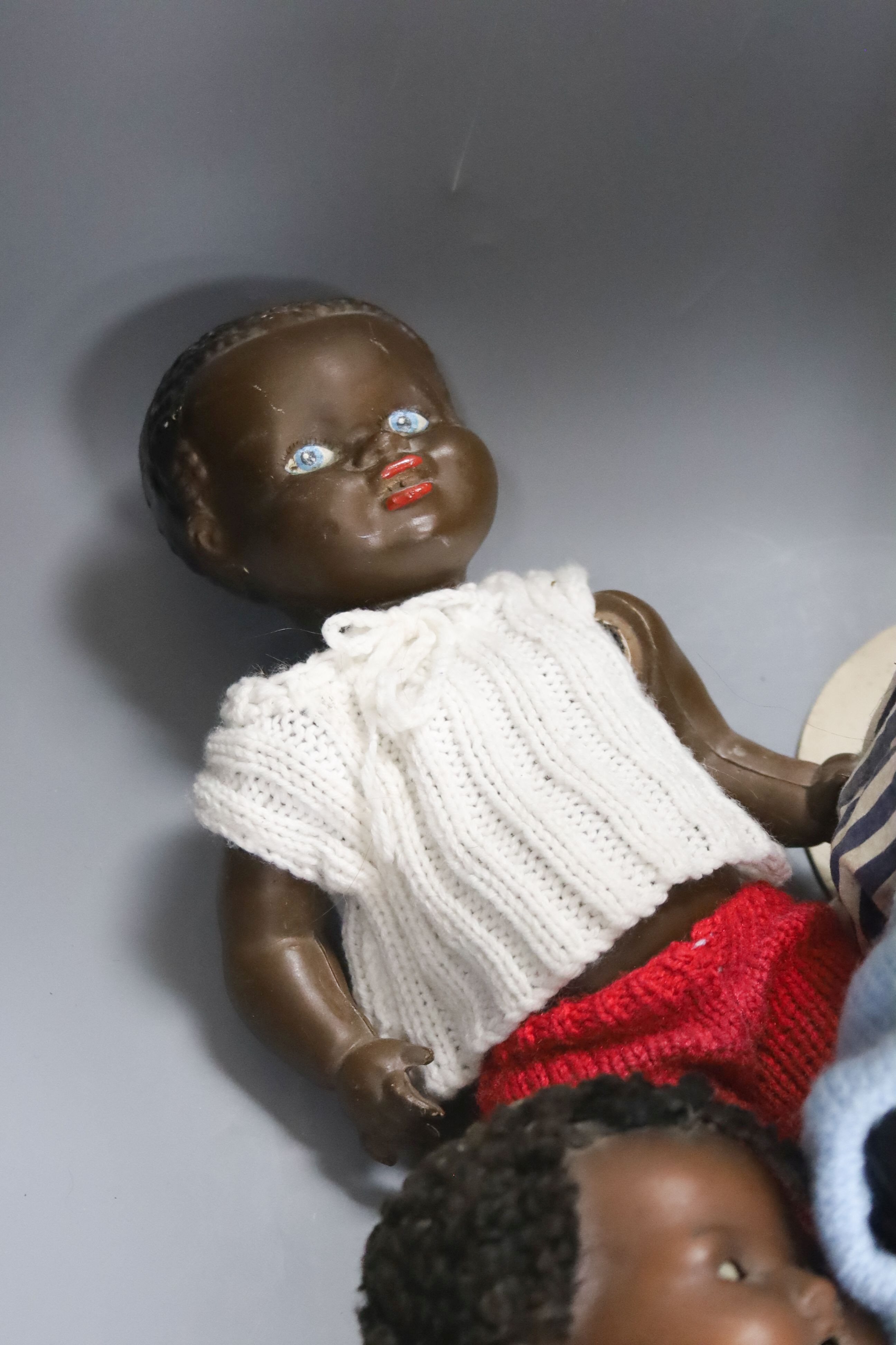 A black AM 351 cracked neck Schoneau & Hoffmeister jointed doll H13in. Black cream baby with wig crack to head H14in. two black dolls, one wood large sailor doll 20in.